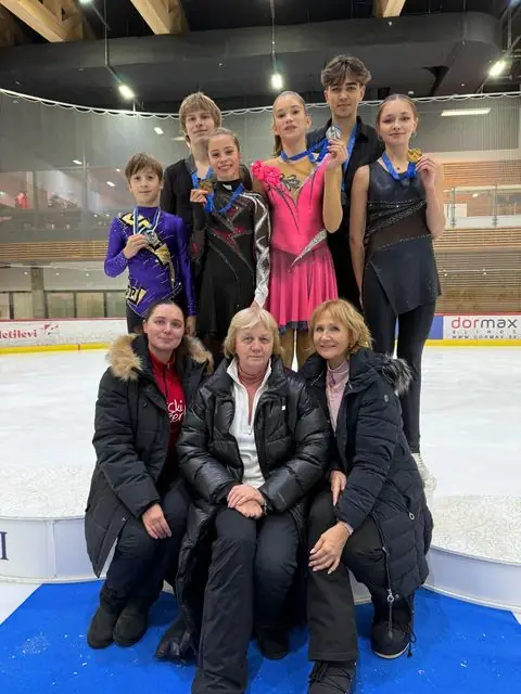 Medalitega noored uisutajad koos treeneritega ühispildil jäähallis