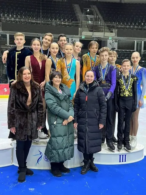 Medalitega uisutajad ja treenerid poodiumil võistluse autasustamisel