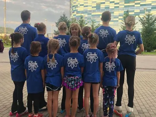 Uisukooli lapsed klubisärkides koos treeneriga jäähalli ees õues