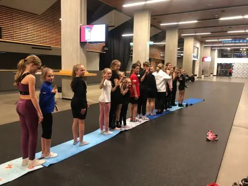Lapsed rivis võimlemismattidel üldkehalisel treeningul jäähalli fuajees