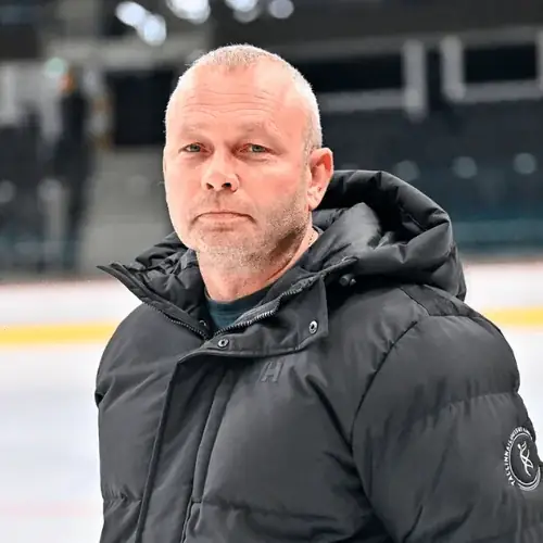 Paljaksihiline mees mustas paksus talvekonnas seiseb jäähalli keskel