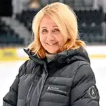 Blondi naine mustas paksus talvekonnas kapuutsiga, seiseb uduse tausta ees